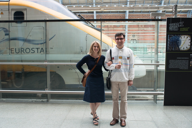 A picture of a man standing nearby speedy trains at St. Pancras Station